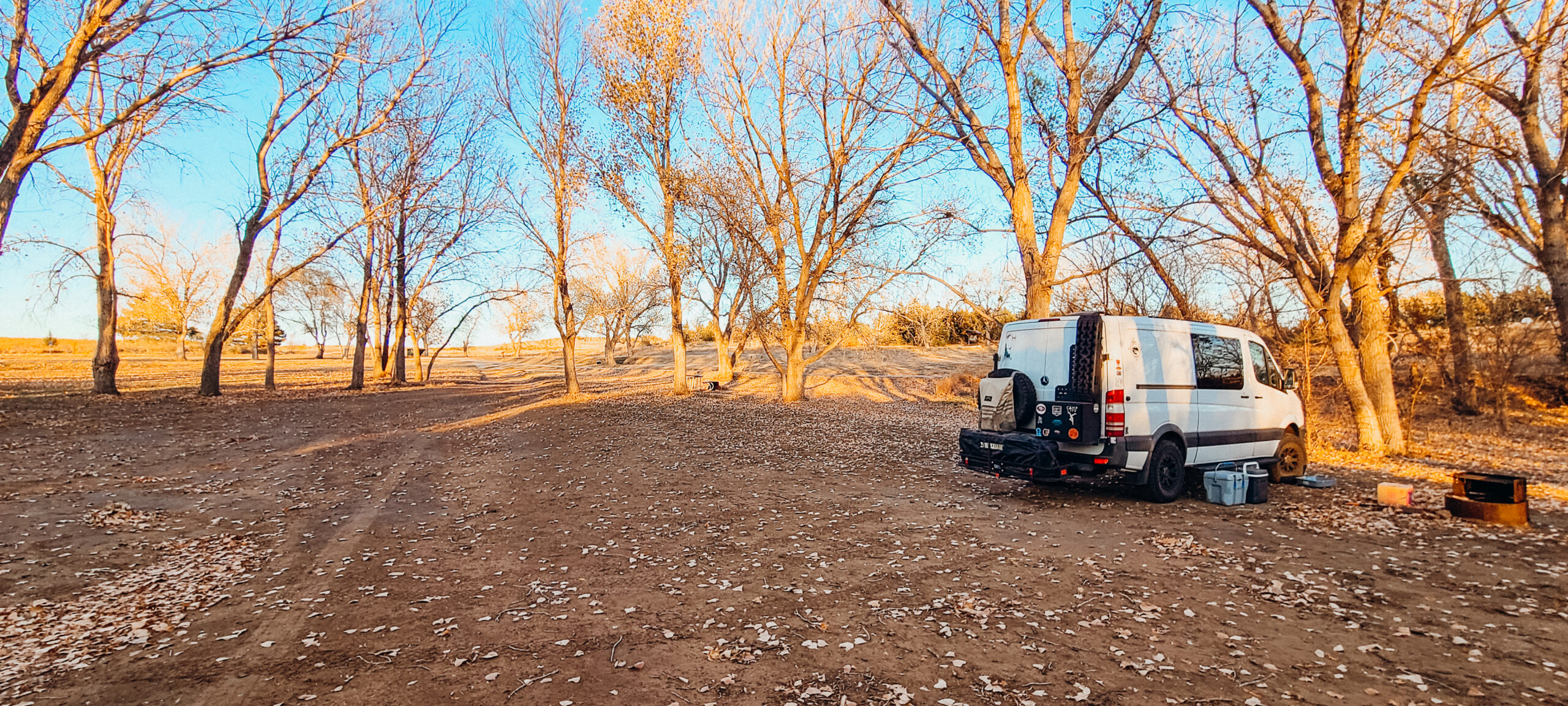 Sprinter van parked at a fall covered campsite in Wilson State Park in Kansas