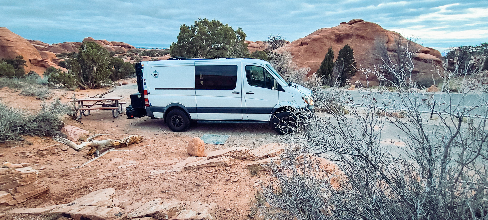 Sprinter van parked at a camp site in Devils Garden Campground in Arches National Park