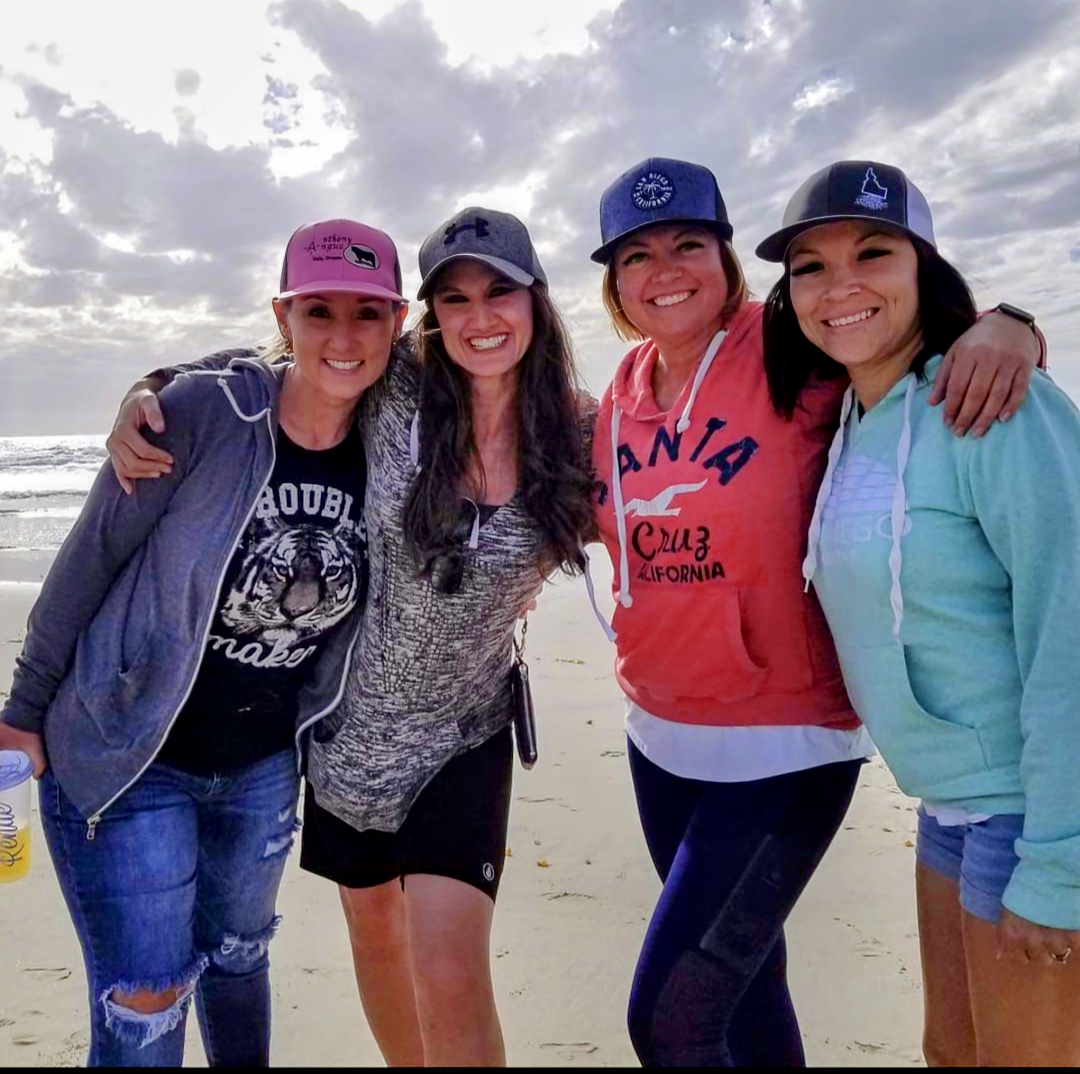 Women on a girls getaway to San Diego smiling on the beach.